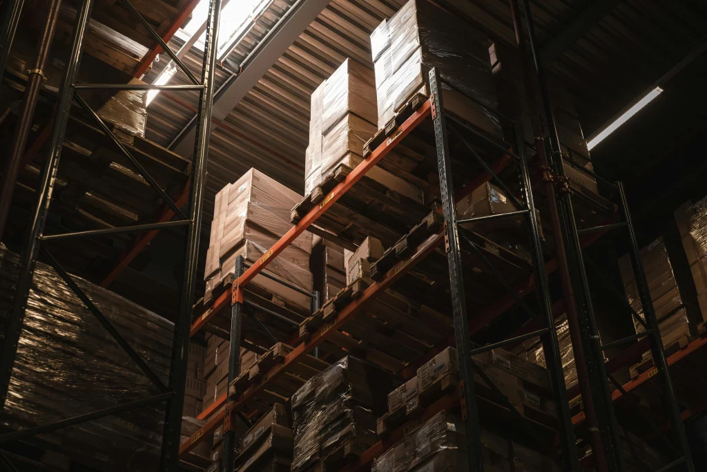 Upwards perspective of racking and stored goods in a warehouse that needs a fire suppression system